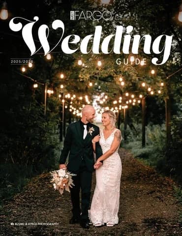Meet Fargo Wedding Guide 2025/2026 cover: bride and groom under string lights on a tree-lined path