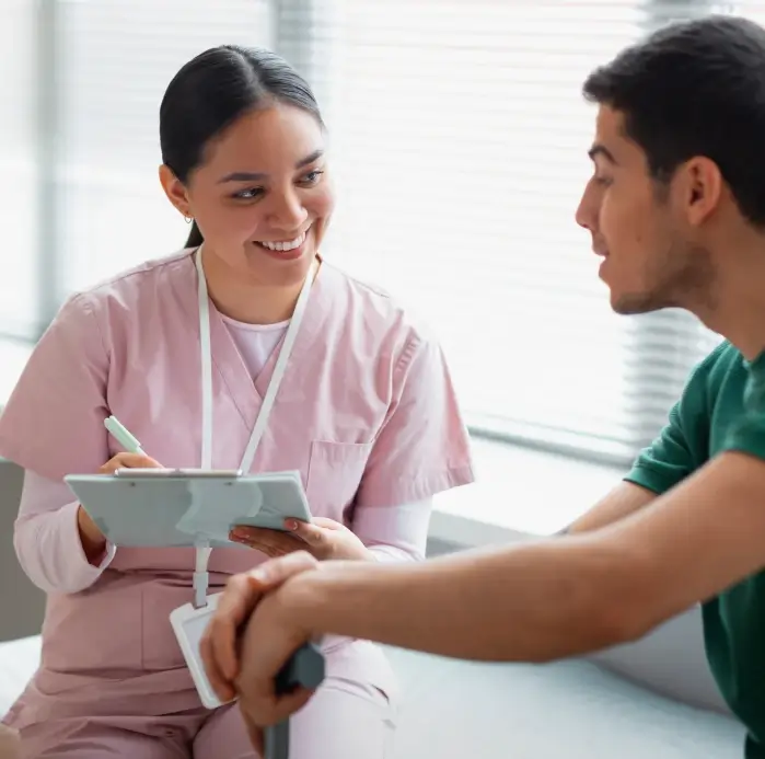 A Woman In Pink Scrubs And A Man In A Green Shirt