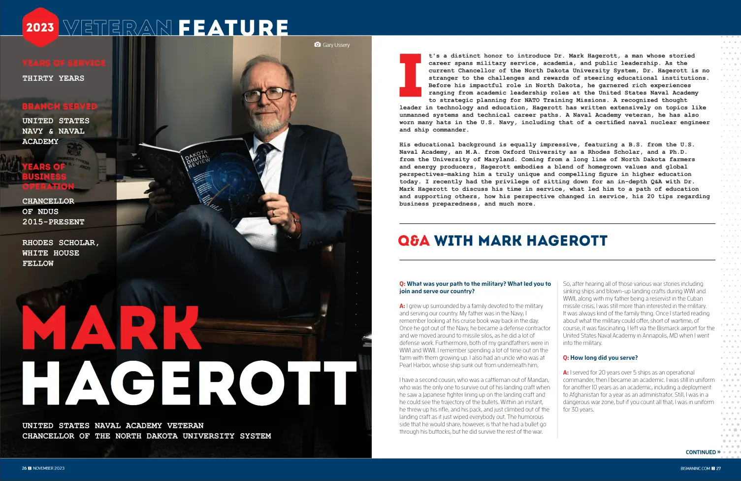 a man in a suit sitting in a chair reading a book